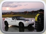 Weißer Tesla am Start, es handelt sich um einen Sportwagen mit Elektroantrieb, der 200 km/h schnell fahren kann und nur ca. 4 Sekunden von 0 auf 100 braucht. Bei vernünftiger Fahrweise kommt man bis zu 400 km weit!